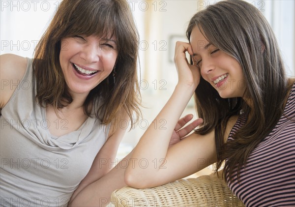 Portrait of mom and teenage girl (14-15) laughing at home