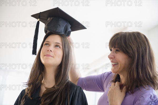 Teenage girl (14-15) getting ready for graduation ceremony