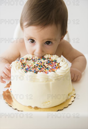 Baby girl (12-17 months) eating birthday cake