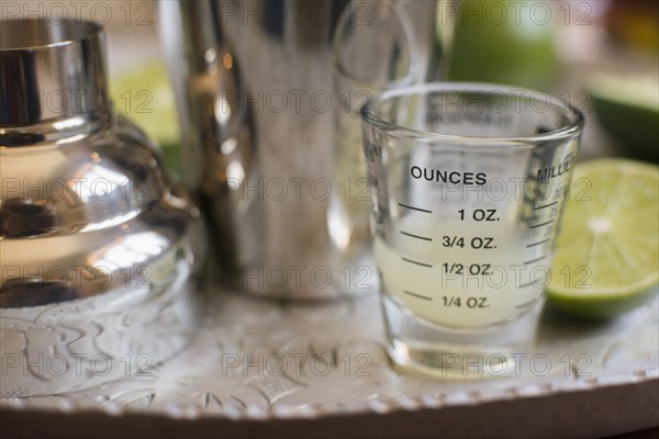 Shot glass and cocktail shaker on tray