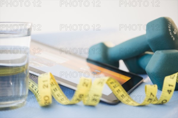 Dumbbells, tape measure and digital tablet