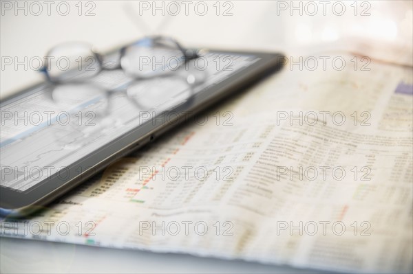 Newspaper, eyeglasses and digital tablet