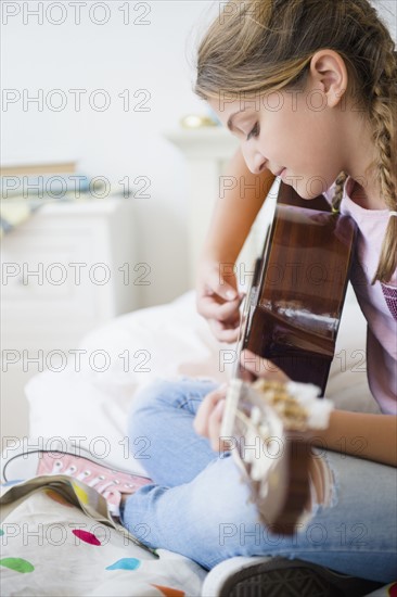 Girl (12-13) playing guitar