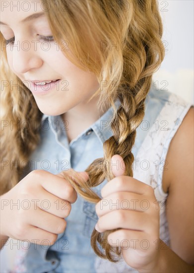Girl (12-13) plaiting braids