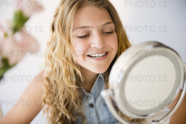 Girl (12-13) smiling to mirror