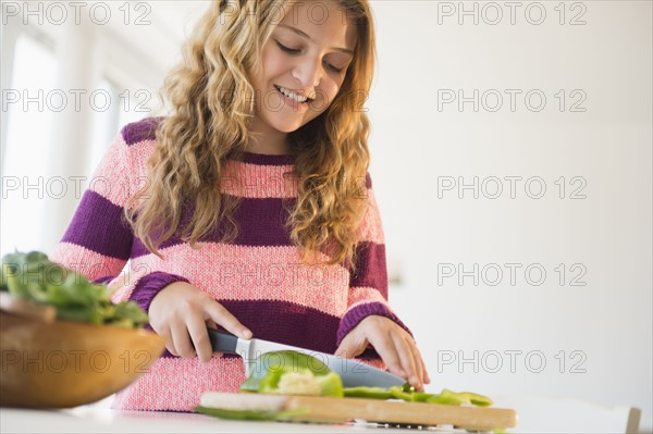 Girl (12-13) preparing salad