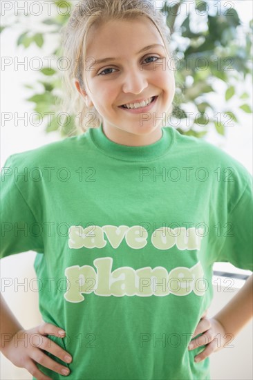 Portrait of smiling teenage girl (12-13) wearing green t-shirt