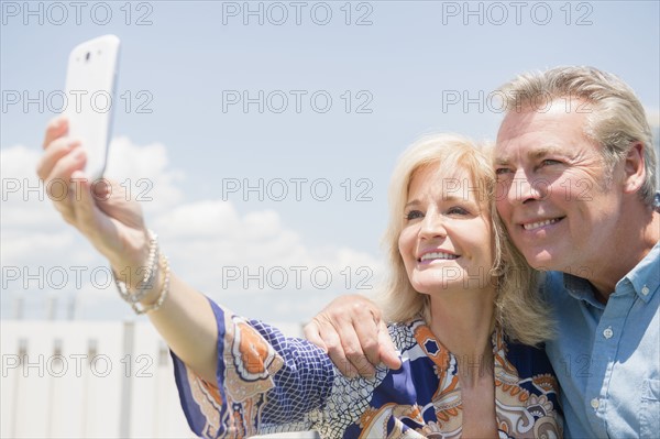 Portrait of couple posing for smartphone selfie