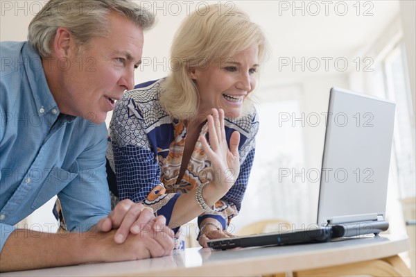 Portrait of couple looking at laptop screen