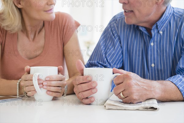 Cropped shot of husband and wife drinking coffee and talking