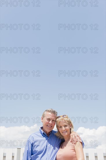 Portrait of smiling couple against sky