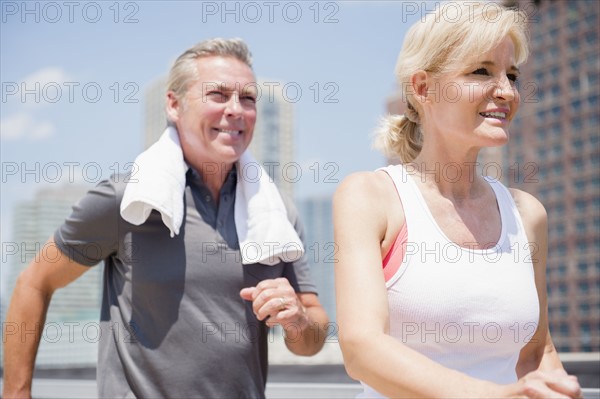 Portrait of couple jogging in city