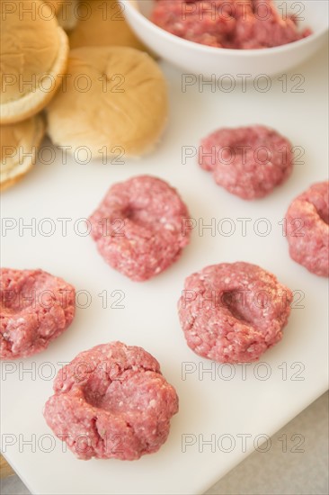 Close-up shot of meatballs in row on white cutting board