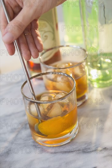 Studio shot of woman's hand stirring drink