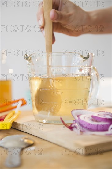 Studio shot of woman's hand stirring liquid in jug