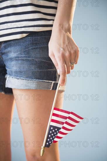 Studio shot of woman's hand holding American flag