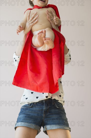 Studio shot of mother holding baby daughter (18-23 months)