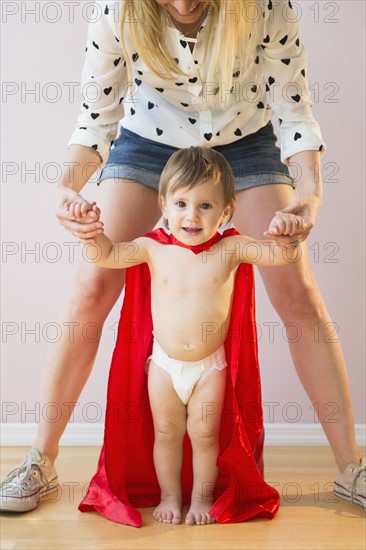 Studio shot of mother holding baby daughter (18-23 months) in costume