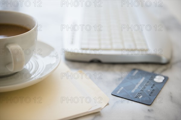 Studio shot of coffee cup, computer keyboard, files and credit card