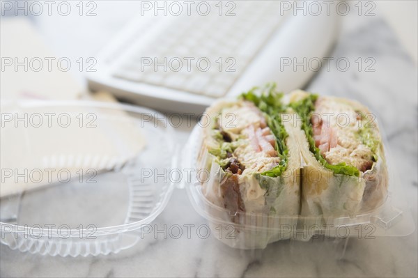 Studio shot of sandwich in box and computer keyboard