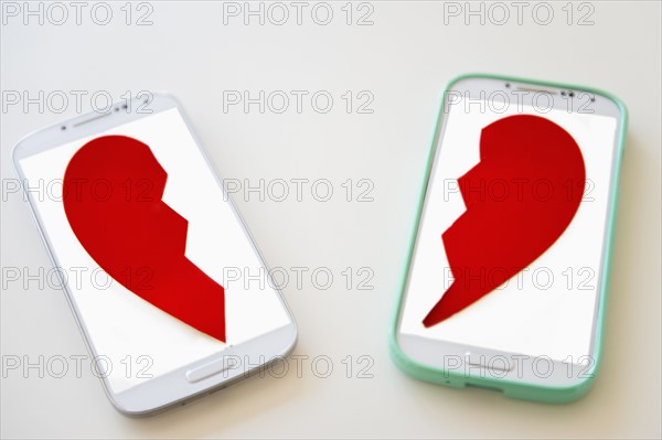Studio shot of smart phones with broken heart on screen