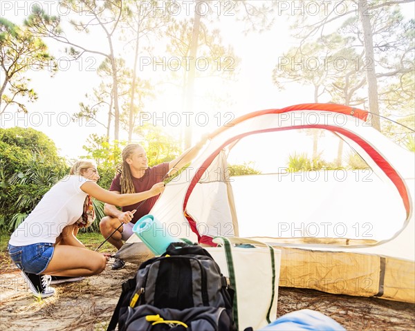 Couple setting up tent in forest