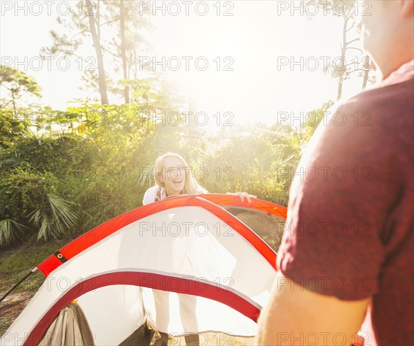 Couple setting up tent in forest