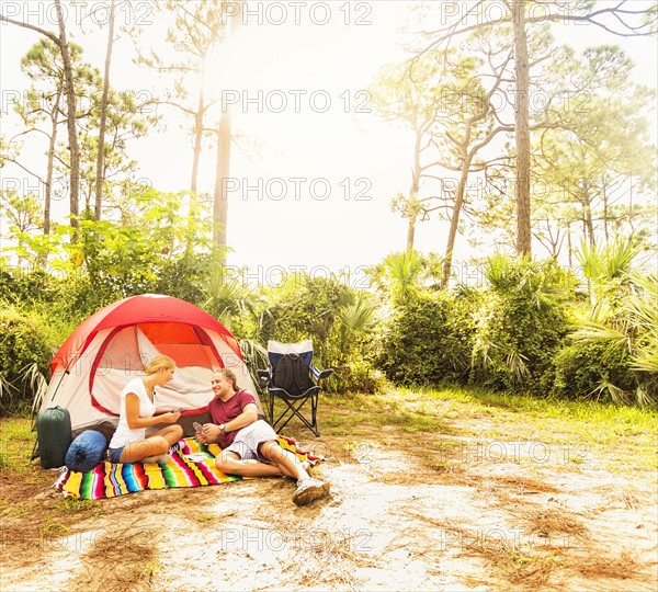 Couple playing cards in front of tent