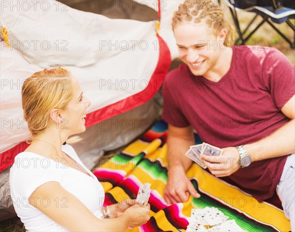 Couple playing cards in front of tent