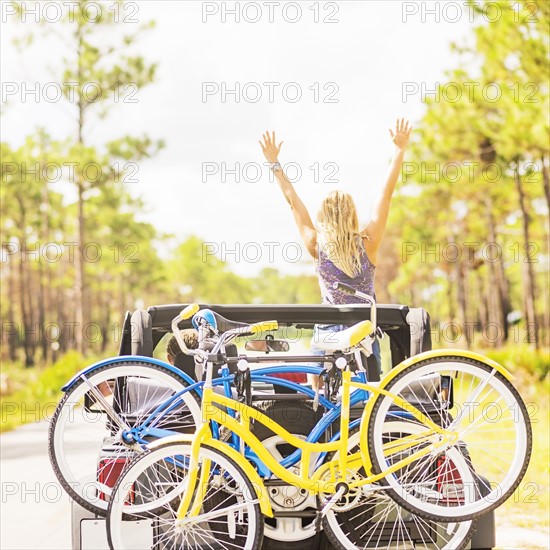 Woman rising hands in car