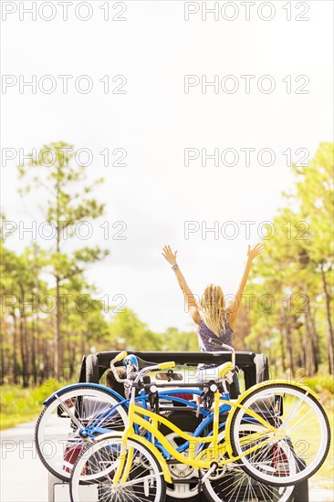 Woman rising hands in car