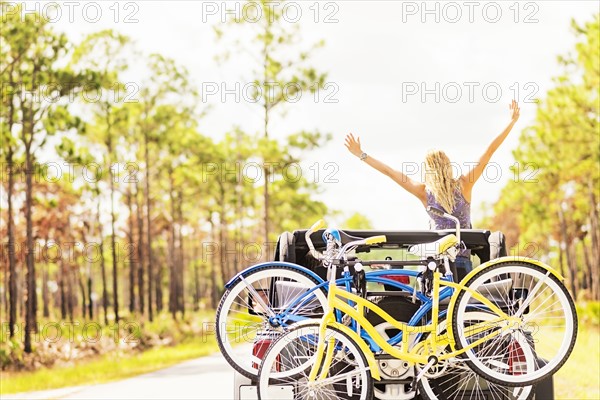 Woman rising hands in car