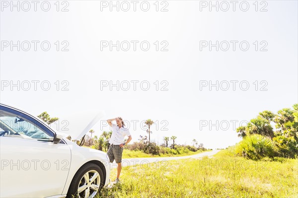 Young man looking at car engine