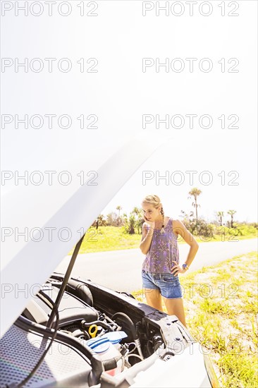 Woman looking at car engine