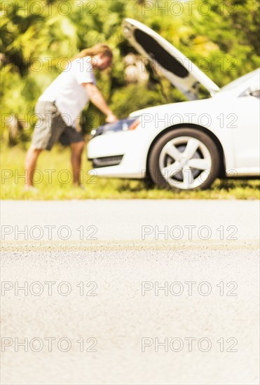 Young man looking at car engine