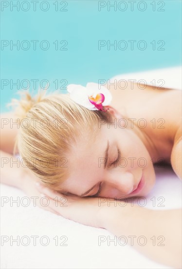 Woman lying next to swimming pool