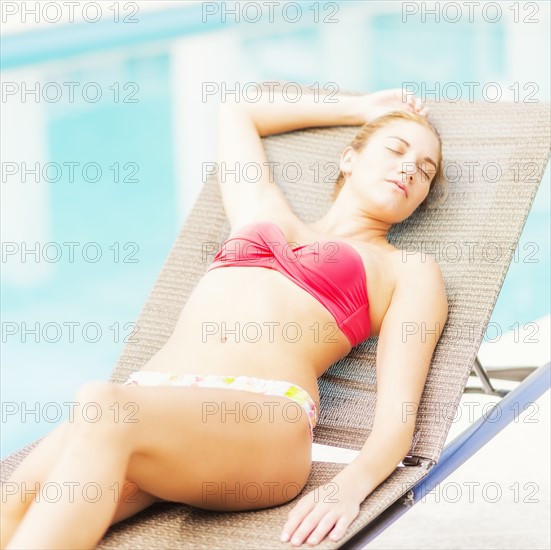 Woman lying on next to swimming pool