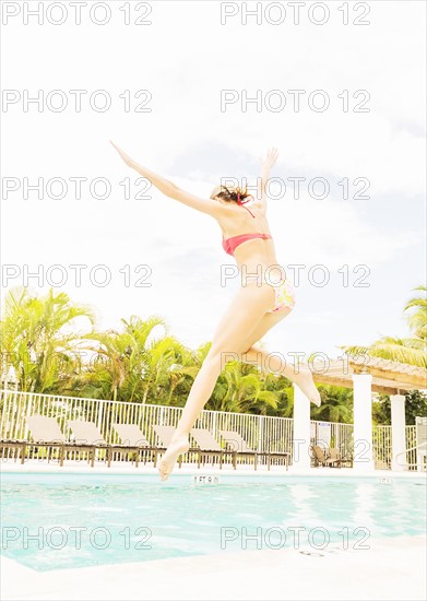 Woman jumping into swimming pool