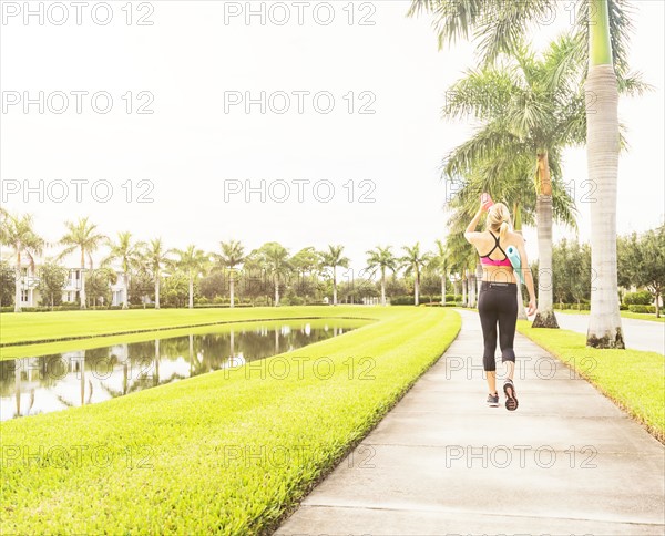 Woman walking along promenade drinking water
