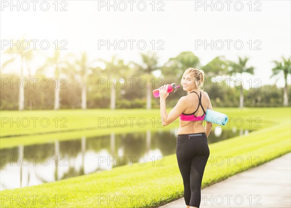 Woman walking along promenade drinking water