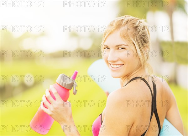 Portrait of smiling woman drinking water