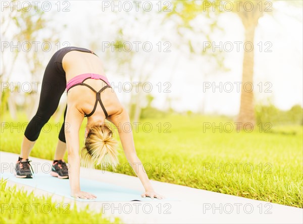 Young woman stretching in park