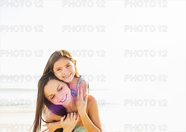 Portrait of smiling girl (6-7) with her mom on beach