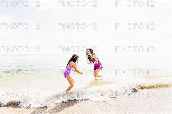 Girl (6-7) and her mom enjoying themselves on beach