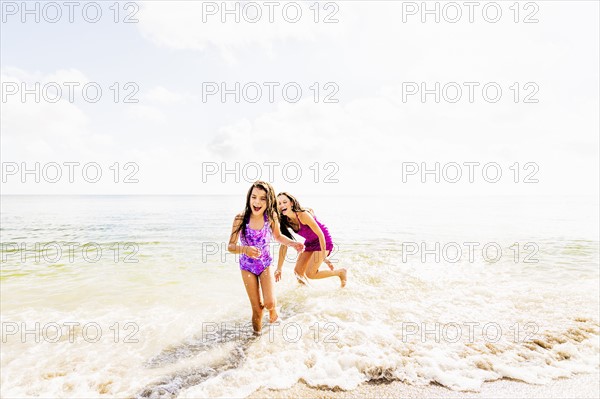 Girl (6-7) and her mom enjoying themselves on beach