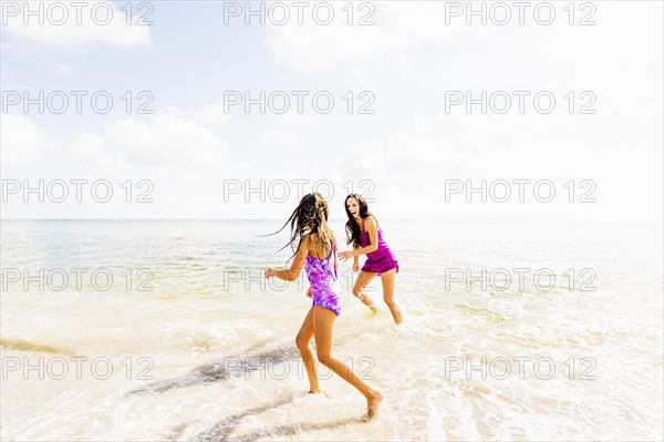 Girl (6-7) and her mom enjoying themselves on beach
