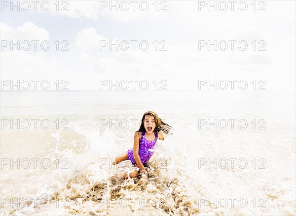 Girl (6-7) having fun in water