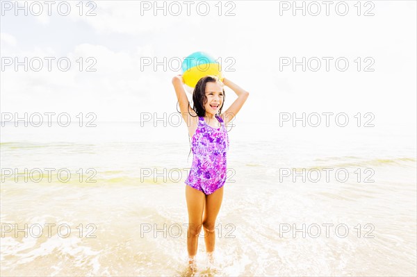 Girl (6-7) playing with ball on beach