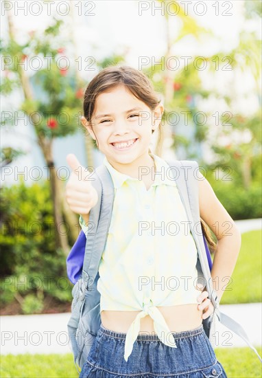 Portrait of girl (6-7) with thumbs up