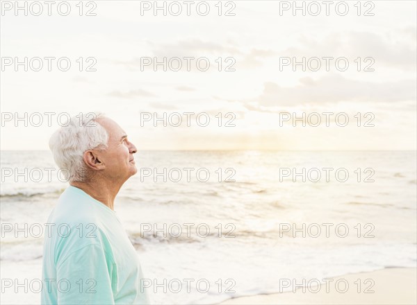 Side view of senior man smiling on beach